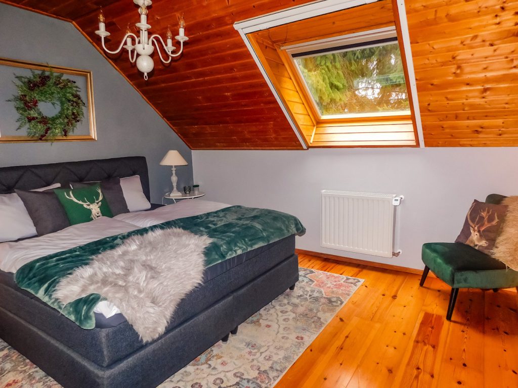 Schlafzimmer mit Boxspringbett, Nachttischen und Deko