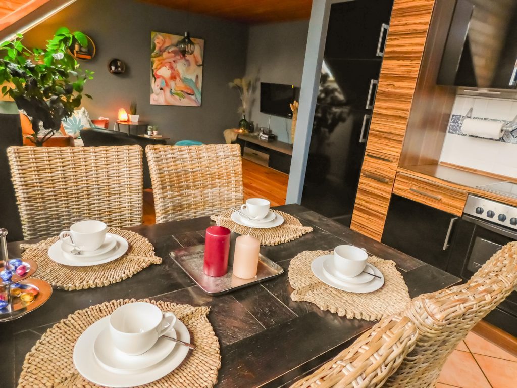 Blick vom Esstisch in das Wohnzimmer, rechts die Küche zu sehen